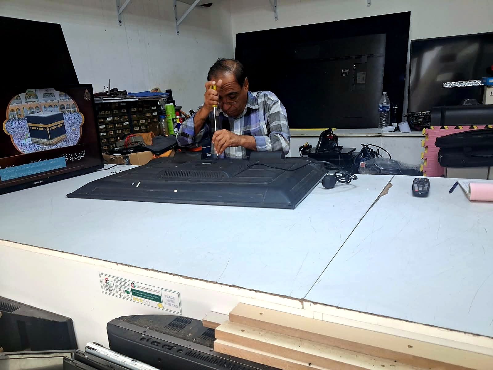 Technician repairing a television at Omer Rajab Electronics